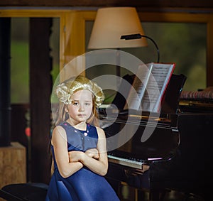 Cute little girl playing piano, dressing in retro Mozart periwig