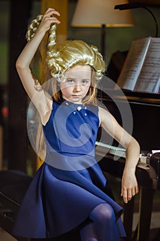 Cute little girl playing piano, dressing in retro Mozart periwig