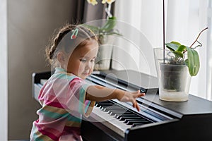 Cute little girl playing piano at a music school