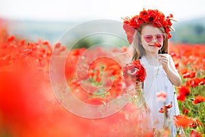 Cute little girl playing in red poppies field summer day beauty and happiness France