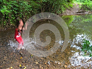 Cute little girl playing in river.