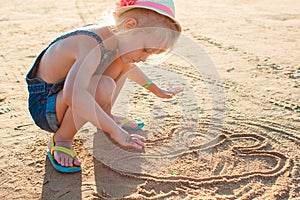 Cute little girl playing with sand on the beach