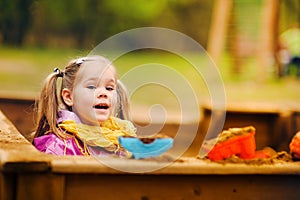 Cute little girl playing in a sandbox