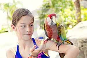 Cute little girl playing with a Scarlet Macaw Parrot