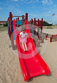 cute little girl playing in a slide in a park