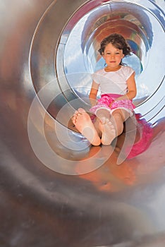 cute little girl playing in a slide in a park