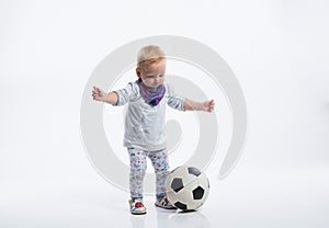 Cute little girl playing with soccer ball. Studio shot.