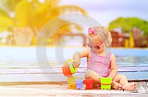 Cute little girl playing in swimming pool at beach