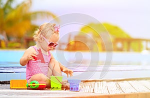 Cute little girl playing in swimming pool at beach