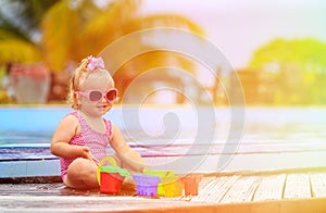 Cute little girl playing in swimming pool at beach