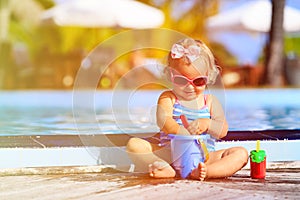 Cute little girl playing in swimming pool at beach