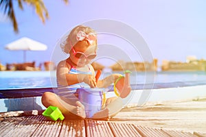 Cute little girl playing in swimming pool at beach