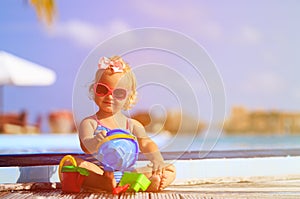 Cute little girl playing in swimming pool at beach