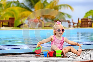 Cute little girl playing in swimming pool at beach