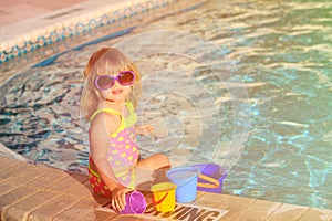 Cute little girl playing in swimming pool at beach