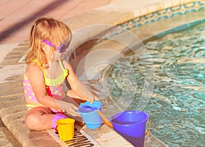 Cute little girl playing in swimming pool at beach