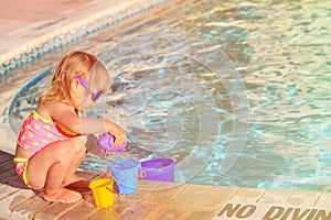 Cute little girl playing in swimming pool at beach