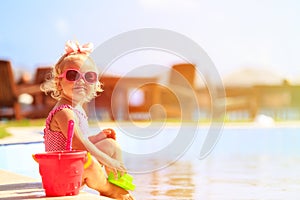 Cute little girl playing in swimming pool at beach