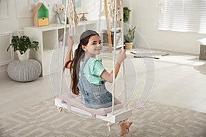 Cute little girl playing on swing