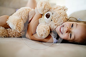 Cute little girl playing with teddy bear