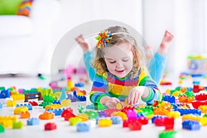 Cute little girl playing with toy blocks