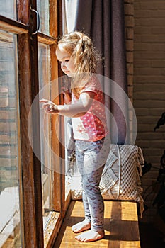 Cute little girl playing at the window