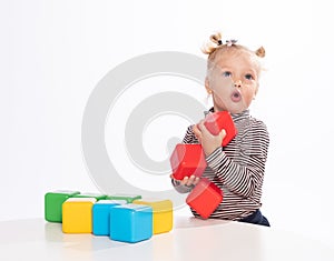 Cute little girl plays with blocks