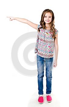 Cute little girl is pointing to the side isolated