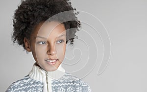 Cute little girl portrait. Funny child wearing winter sweater studio shot. Isolated on grey background