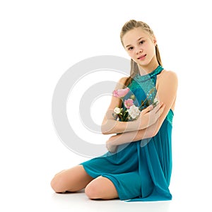 Cute little girl posing in the studio with a bouquet of small rose