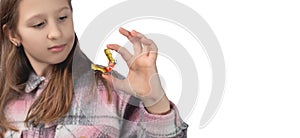 Cute little girl posing in the studio holding an orthodontic appliance in her hand. The concept of oral hygiene in childhood.