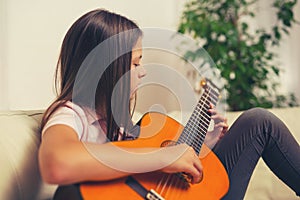 Cute little girl practicing her guitar lessons