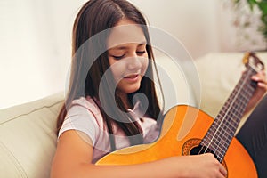 Cute little girl practicing her guitar lessons