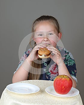 Cute little girl preferred hamburger instead of apple