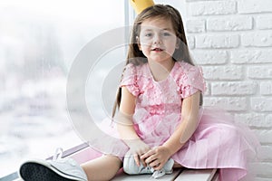 Cute little girl in a princess costume. Pretty child preparing for a costume party. Beautiful queen in gold crown.