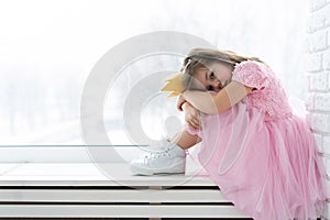 Cute little girl in a princess costume. Pretty child preparing for a costume party. Beautiful queen in gold crown.