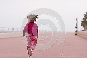 Cute little girl on the promenade by the sea