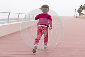 Cute little girl on the promenade by the sea