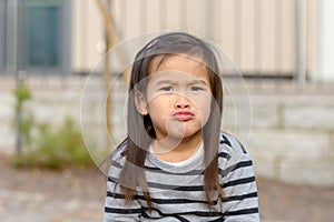 Cute little girl pulling a funny face at camera