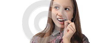 A cute little girl is putting on an orthodontic appliance. The concept of oral hygiene in childhood. Studio photo on a white