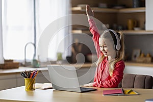 Cute Little Girl Raising Hand During Online Lesson On Laptop At Home