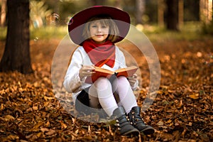 Cute little girl read interesting book in autumn