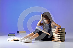 Cute little girl is reading a book.