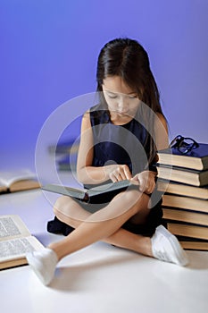 Cute little girl is reading a book.