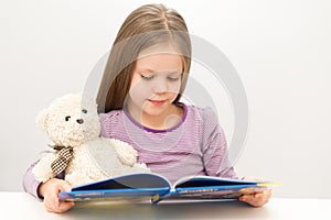 Cute little girl reading a book