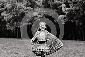 Cute little girl reading a book in autumn park