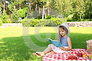 Cute little girl reading book . Summertime rest