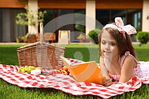 Cute little girl reading book. Summertime rest