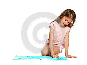 Cute little girl reading book on white