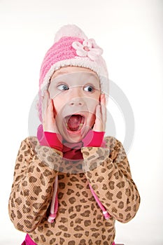 Cute little girl in red hat holding hands to face in surprise